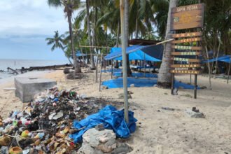 Tumpukan sampah dan jejeran terpal biru di Pulau Beras Basah.